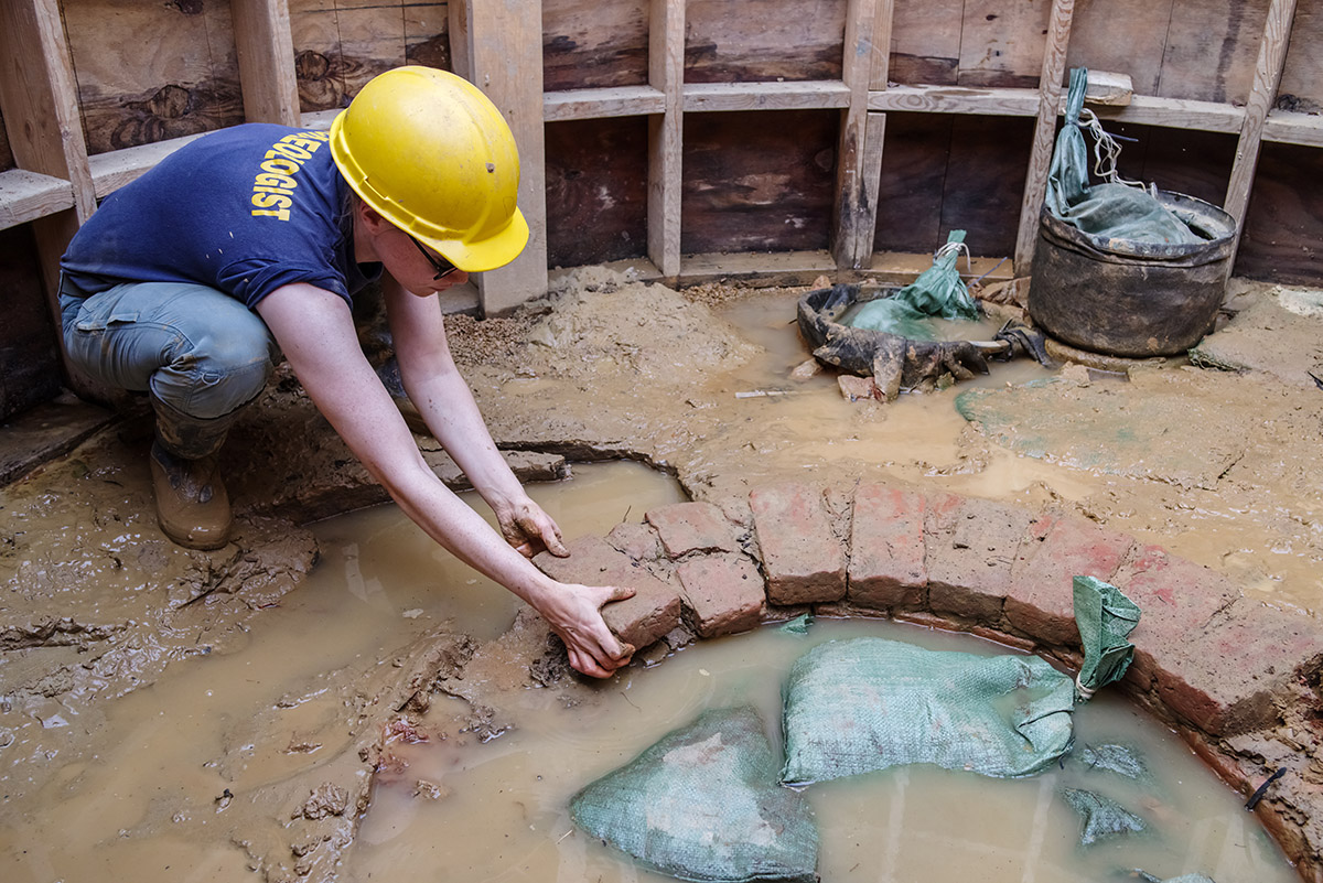 Staff Archaeologist Natalie Reid removes the ninth course of the Governor's Well for conservation and curation.