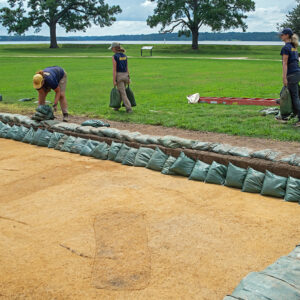 Archaeological Field Technician Hannah Barch, Staff Archaeologist Ren Willis, and Archaeological Field Technician Katie Griffith prepare the excavations south of the Archaearium for the approach of Hurricane Erin. The Hurricane's eye stayed well into the Atlantic but it caused flooding nonetheless.