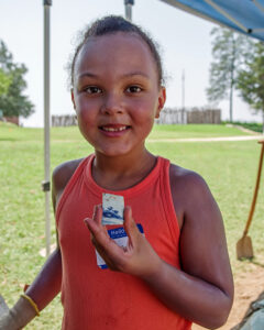 A camper shares a sherd of Chinese porcelain that she found at the borrow pit excavations.