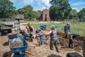 The archaeology team removes the backfill at the 1607 Burial Ground. The black filter fabric on the ground was placed there in the 2000s by archaeologists after completing their excavations to protect the archaeological resources underneath.