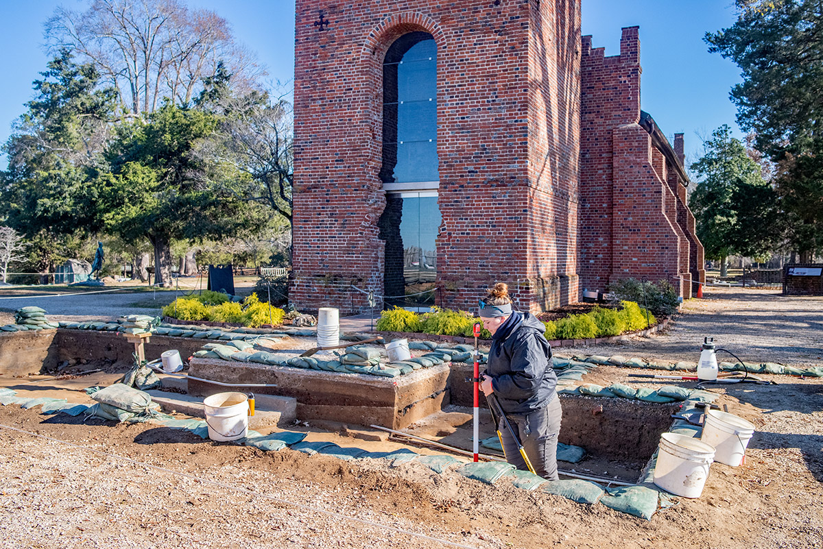 Archaeological Field Technician Hannah Barch helps survey features in the excavations west of the Church Tower.