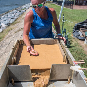 Collections Assistant Lindsay Bliss uses the flotation tank to process excavated soil samples. The machine separates objects based on density and can capture tiny objects such as seeds other botanicals.