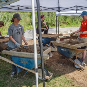 (L-R) Archaeological Field Technicians Gabriel Brown and Ren Willis, and Archaeological Interns Eleanor Robb and Janne Wagner screen for artifacts while Archaeological Field Technician Josh Barber conducts excavations. This is at the clay borrow pit excavations.