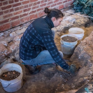 Archaeologist excavates floor of brick church tower