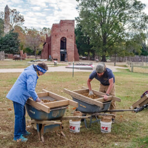 Volunteer Cynthia Garman-Squier and Archaeological Field Technician Josh Barber screen for artifacts in the soil excavated from the 1607 burial ground.