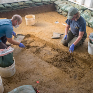 Director of Archaeology Sean Romo and Archaeological Field Technician Eleanor Robb excavate the top layers of the Smithfield burial.