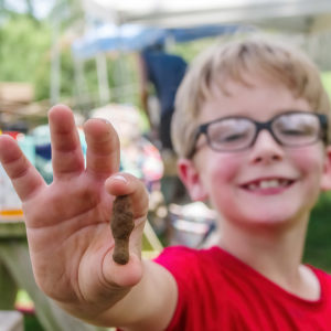 A camper holds a heavily rusted iron object he found during screening.