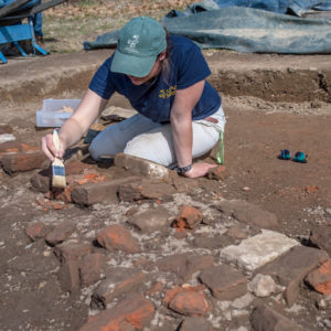 Archaeologist brushes off excavated bricks