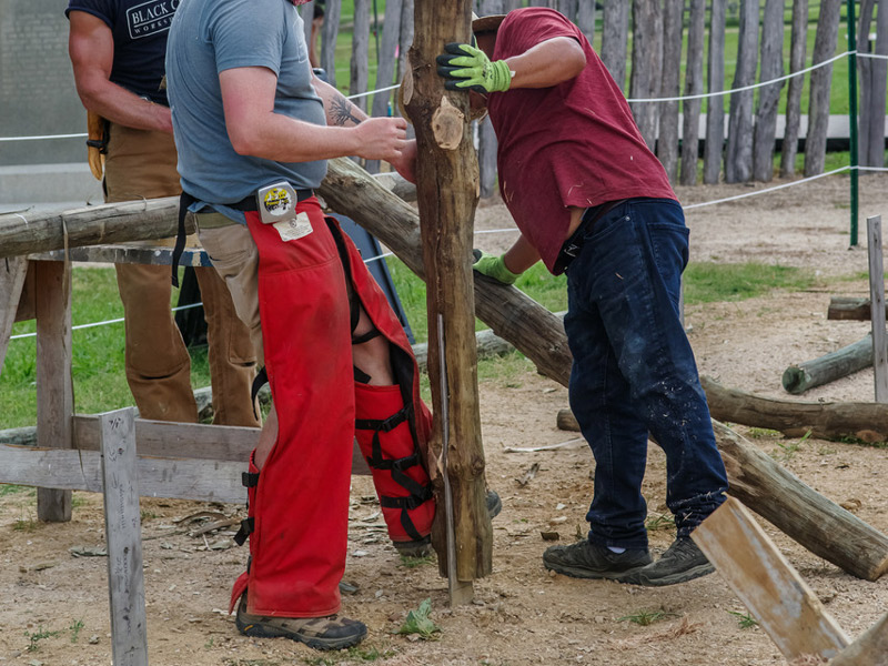 workers fitting a notched post onto an upright footer in the ground
