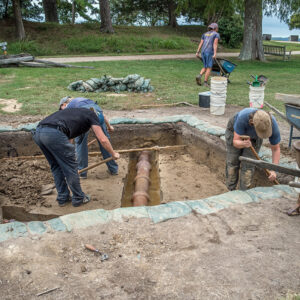 The team works around a large drainage pipe installed to prevent flooding at Fort Pocahontas (seen at rear). A smaller pipe running left/right in the photo used to provide water to a horse trough that has since been relocated.