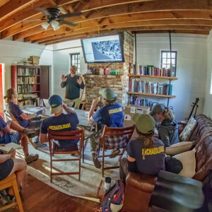 The archaeology team discusses upcoming projects in the Godspeed Cottage.