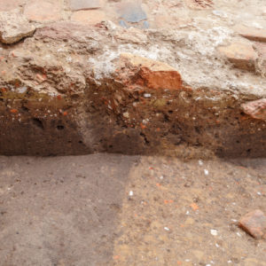 Brick and mortar fragments within an excavation unit