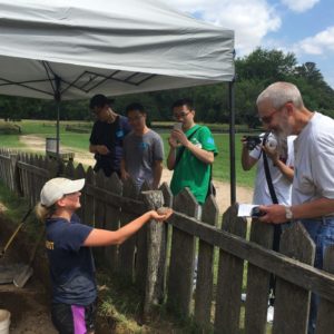 Archaeologist shows visitors a cannonball