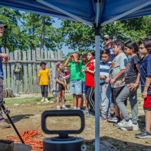Director of Archaeology Sean Romo discusses the excavations at the 1607 Burial Ground with a group of schoolchildren.