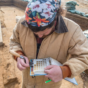 Archaeological Field Technician Josh Barber uses a Munsell Soil Color Chart to classify the color of soil he excavated from the excavations west of the Church Tower.