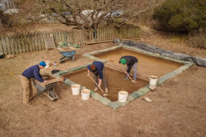 Staff Archaeologist Caitlin Delmas screens for artifacts while Archaeological Field Technician Hannah Barch and Staff Archaeologist Gabriel Brown conduct excavations just outside the Godspeed Cottage.