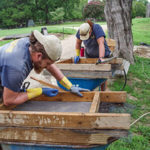 Archaeological Field Technicians Josh Barber and Hannah Barch screen for artifacts from soil excavated from the north field.