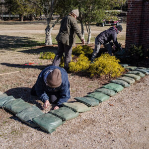 Staff Archaeologist Caitlin Delmas, Archaeological Field Technician Eleanor Robb, and Staff Archaeologist Ren Willis prepare the area near the Colonial Dames of America gate for excavations.