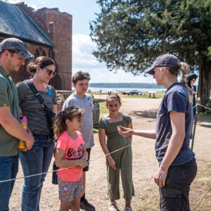 Archaeological Field Technician Katie Griffith shares a small find with visitors.