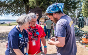 Archaeological Field Technician Josh Barber shares the slate he found with visitors.