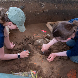 Staff Archaeologists Ren Willis and Natalie Reid excavate artifacts from the top of the well.
