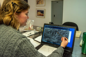 Archaeological Field Technician Eleanor Robb draws maker's marks found on spade nosings in the Jamestown collection.