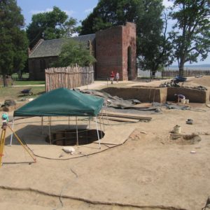 tent over a portion of an excavated area in front of a brick church
