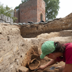 Archaeologist Mary Anna Hartley excavates the close burgonet helmet.