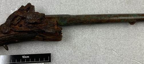 conserved pistol with corroded stock