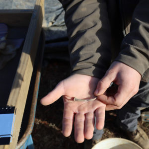 Archaeologist Jack Schreiber holds a nail that was preserved due to exposure to fire
