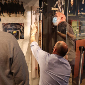 Director of Collections & Conservation Michael Lavin helps install a halberd in the "Gentleman Soldiers" exhibit
