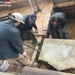 Staff examine broken tombstone