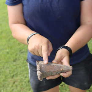 Archaeologist Caitlin Delmas holds the pin maul found in the excavations north of the fort.