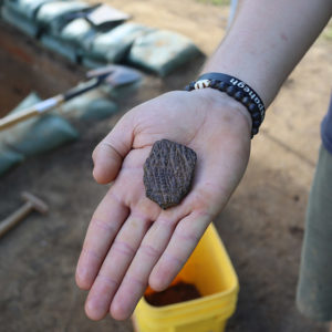 Archaeologist Josh Barber holds a sherd of Virginia Indian pottery found in the Confederate moat.