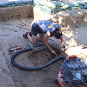 Site Supervisor Anna Shackelford excavates a pit inside one of the squares at the north Church Tower dig.