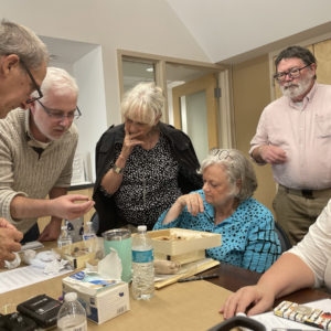 Attendees of the small finds workshop examine a pipe bowl.