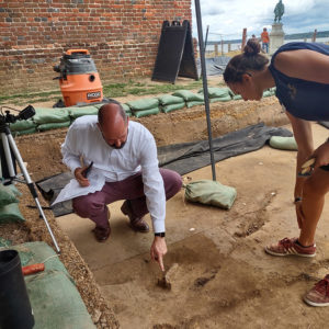 Director of Collections and Conservation Michael Lavin and Site Supervisor Anna Shackelford examine the matchlock lock found at the north Church Tower dig.