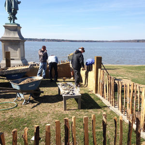 Staff reconstruct low church wall in front of riverbank