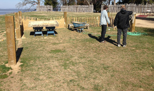 Two staff members examine in-progress reconstructed low church wall