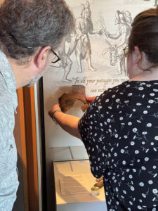 Assistant Curator Lauren Stephens places the mended Potomac Creek pot back on display.