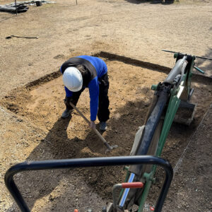 Ren Cam: Staff Archaeologist Ren Willis takes a photo from her perch atop the backhoe as Senior Staff Archaeologist Dr. Chuck Durfor excavates a new square in the North Church dig.
