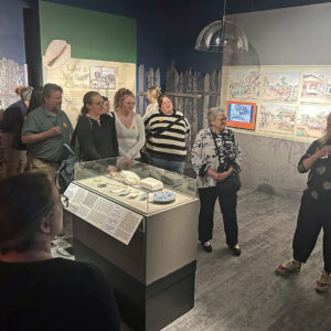 Beverly (Bly) Straube, Senior Curator at the Jamestown Yorktown Foundation, gives a tour of the "Following the Dragon" exhibit to Jamestown Rediscovery staff along with exhibit co-curator Jamestown Rediscovery Senior Curator Merry Outlaw.