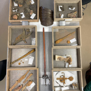 Some of the arms and armor found in the Governor's Well. Modern reproduction tassets and sword at center.