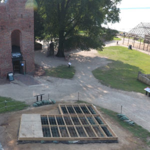 aerial view of an excavation unit covered with a wooden platform next to a brick church
