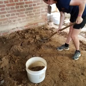 Excavator shovels under brick wall