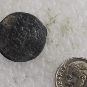 Token next to a dime for scale
