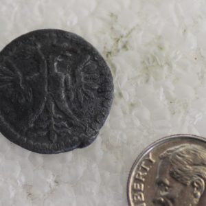 Token next to a dime for scale