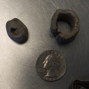 Fishing weights next to a quarter for scale