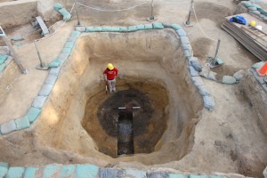 Archaeologist stands in an excavated well