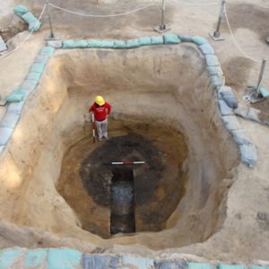 Archaeologist stands in an excavated well